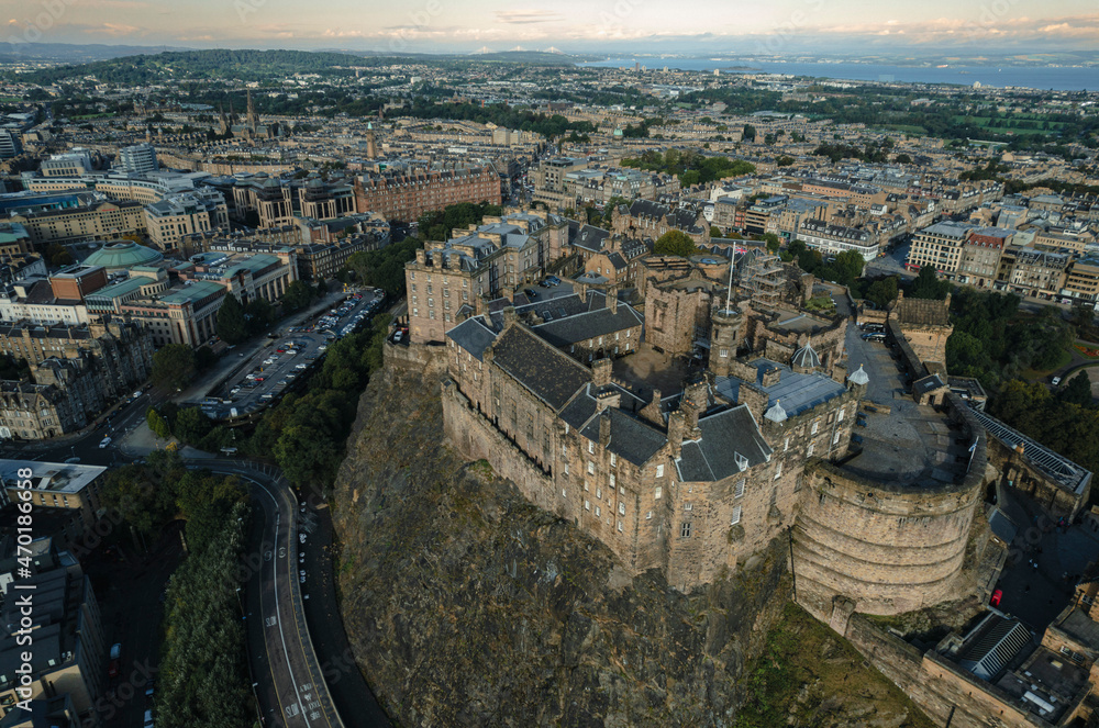 Stunning aerial view of Edinburgh in Scotland, with the castle dominates the skyline, casting its shadow over the surrounding historic town occupying commanding position on volcanic crag with cliffs