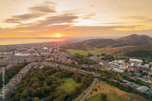 Aerial sunrise view of Holyrood Park is the largest of Edinburgh's royal parks, climb to Arthur's Seat for stunning views of the city, explore the castle where Scottish kings lived or visit museums