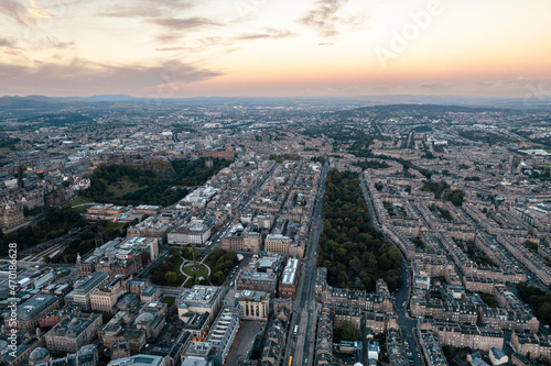 Amazing aerial view of Edinburgh cityscape as sun rises over the city. Old city wakes up with the sunrise. Early morning haze lifts as the first rays of sunlight hit the city of Edinburgh, Scotland