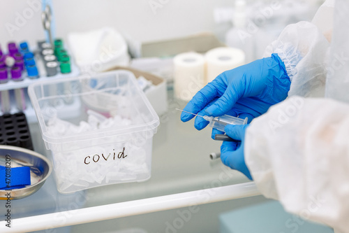 scientist working in laboratory in blue medical gloves doing a covid test 
