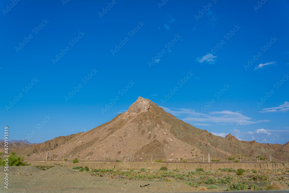 Mount with an ideal conical volcano shape is illuminated by the rising sun in iran with blue sky