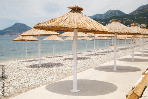 Beach with umbrellas and sun loungers by the sea on a sunny day  Montenegro.