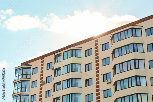 New residential apartment condominium type. Block of flats. City real estate. Simple condo architecture. View of modern sand stucco facade with big bay window balcony and casement solid glass windows