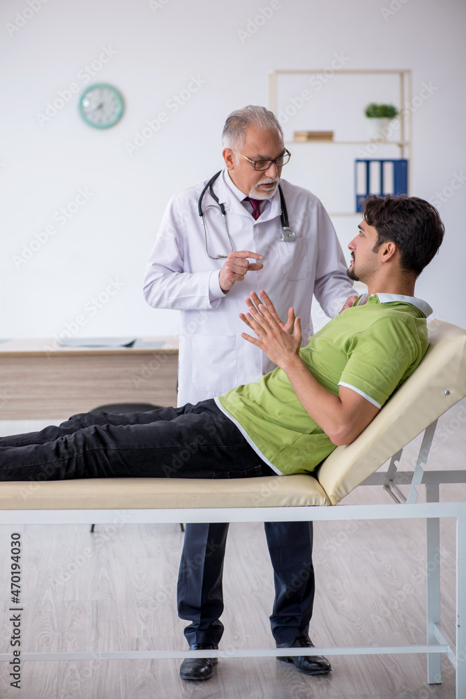 Obraz premium Young male patient visiting old male doctor