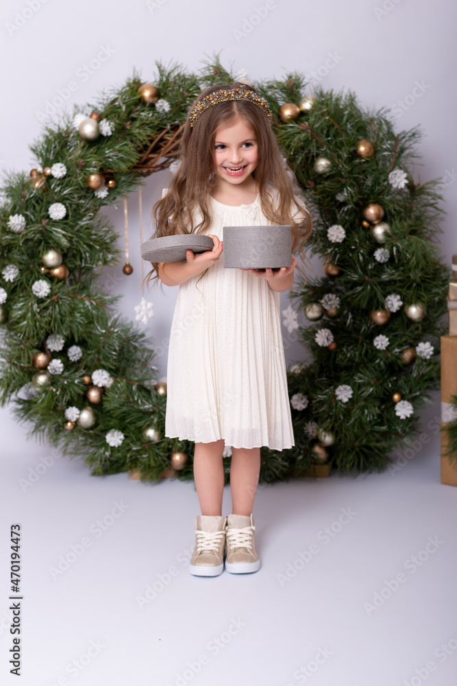 Happy girl smiling near the christmas wreath with gifts. Happy girl smiling near the christmas wreath with gifts.