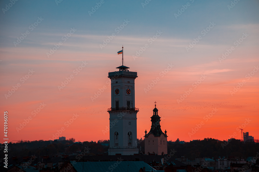 city hall tower building government object of Lviv Ukrainian Western town center landmark place with hanging flag on evening sky background view after sunset time city hall tower building government object of Lviv Ukrainian Western town center landmark place with hanging flag on evening sky background view after sunset time