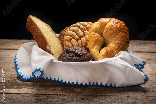 Basket with Mexican sweet breads on a wooden background.