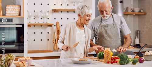 happy and healthy seniors prepare vegan food at home photo