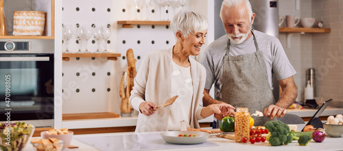 Obraz na plátně happy and healthy seniors prepare vegan food at home