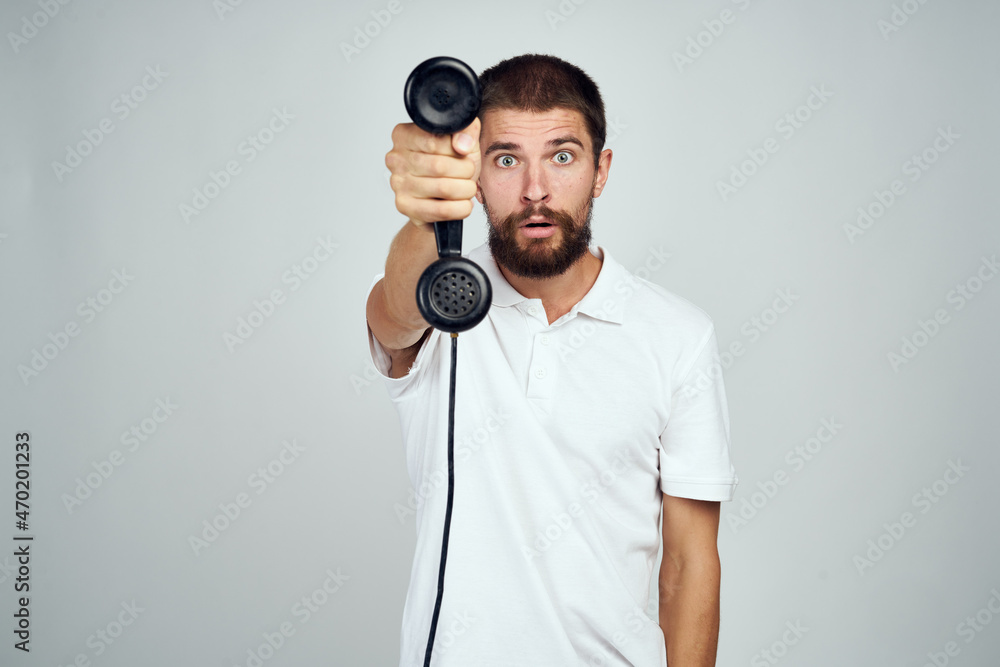 Naklejka premium emotional bearded man talking on the phone light background