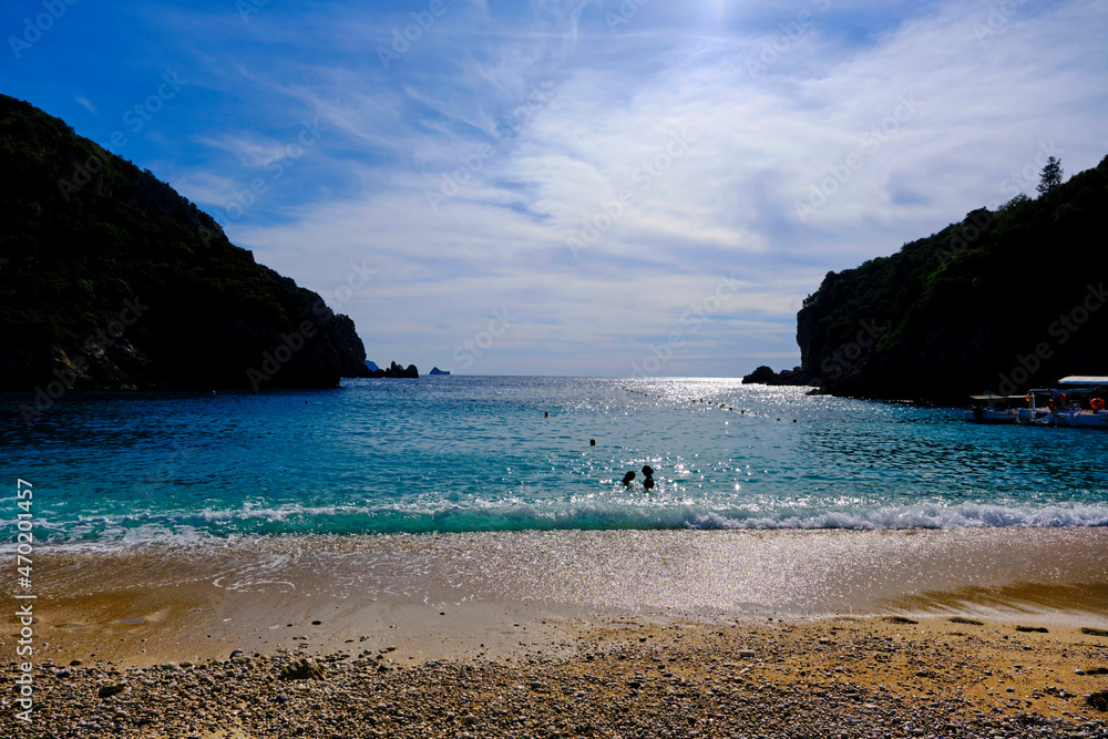 Beach of Paleokastritsa in strong back light with silhouettes in Corfu, Greece