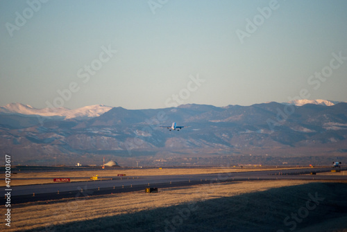 Airplane taking off with Rocky mountains front range in the background as viewed from Denver, Colorado