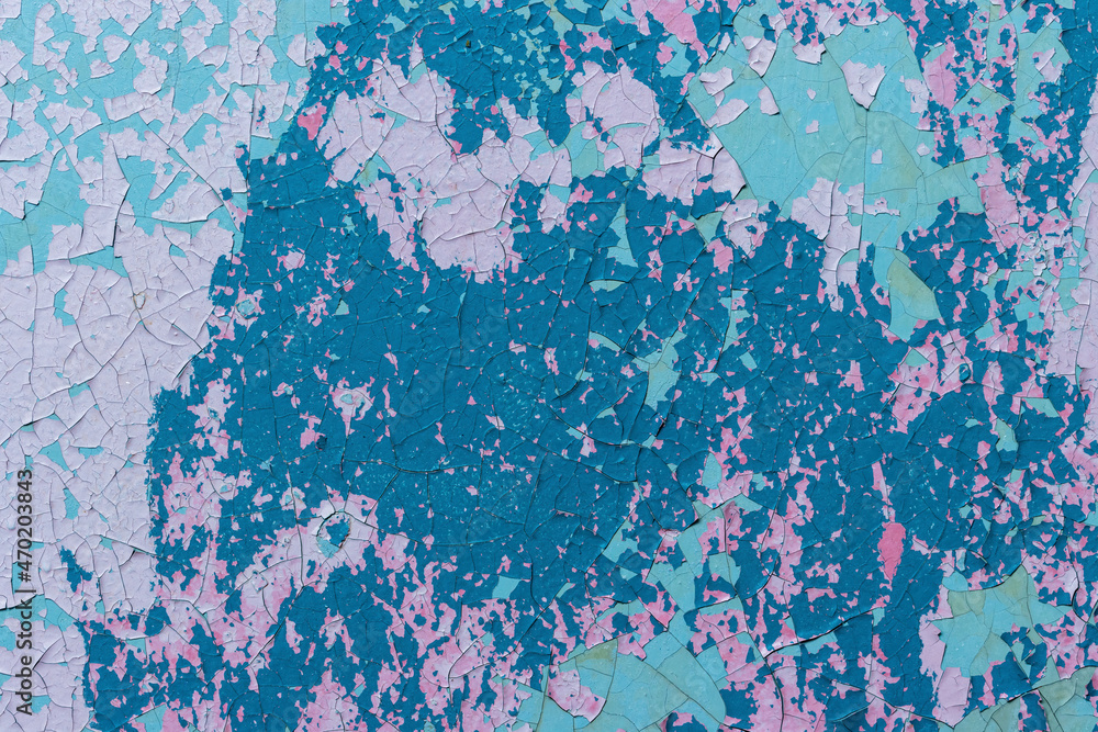 Fototapeta premium Peeling paint on the wall. Old concrete wall with cracked flaking paint. Weathered rough painted surface with patterns of cracks and peeling. High resolution texture for background and design. Closeup
