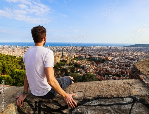 Canvas Print A young man enjoying the view from Bunkers del Carmel over the city of Barcelona, Spain