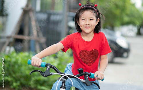 a girl ride a bicycle, kid happy and smile, asian child