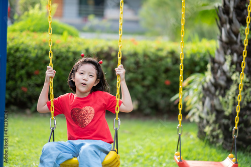 chinese children playing swing, kids have fun with playground, happy girl