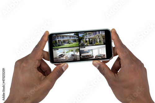 Hand of african american man holding smartphone with view of home from security cameras on screen