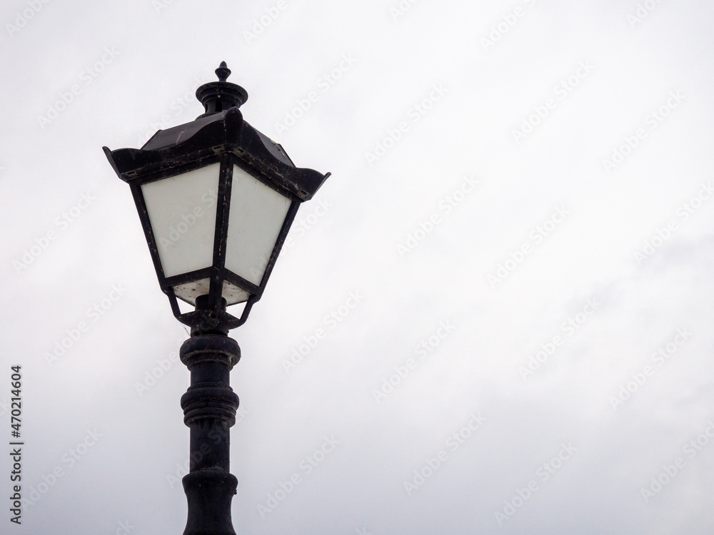 A beautiful street lamp on a background of a gray sky.