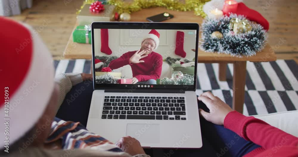 African american mother and daughter using laptop for christmas video call with man on screen African american mother and daughter using laptop for christmas video call with man on screen