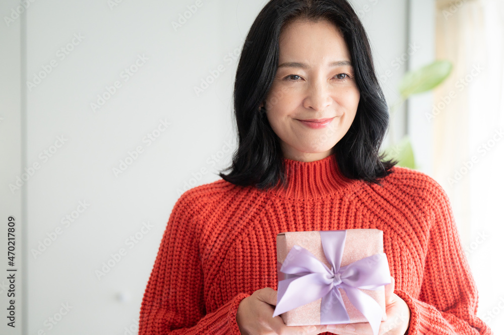 Beautiful Asian (Japanese) woman offering a gift Close-up, looking at camera, copy space Beautiful Asian (Japanese) woman offering a gift Close-up, looking at camera, copy space