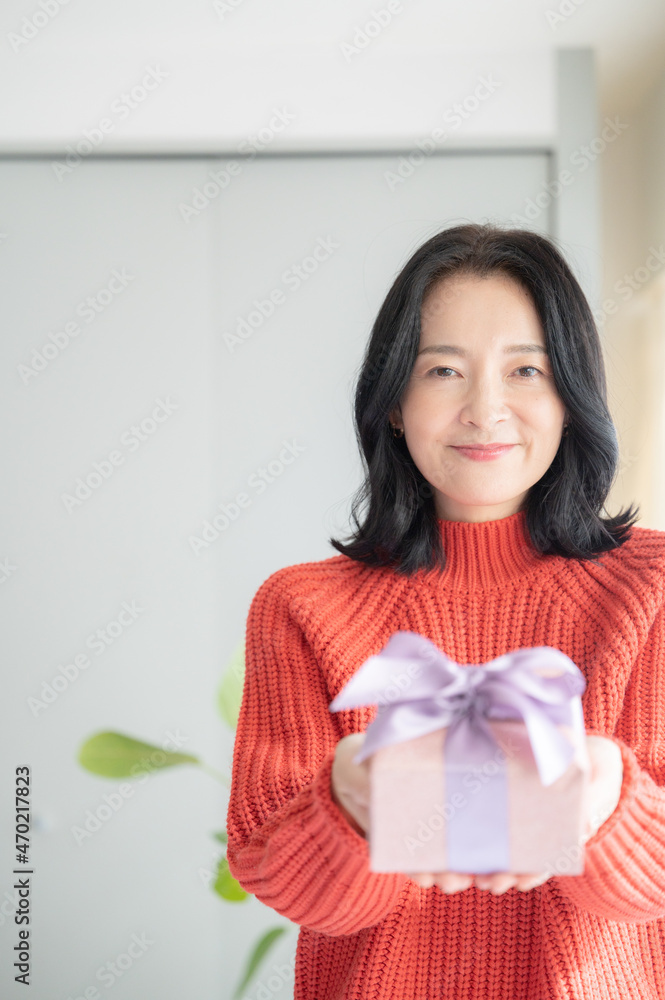 Beautiful Asian (Japanese) woman offering a gift Close-up, looking at camera, copy space Beautiful Asian (Japanese) woman offering a gift Close-up, looking at camera, copy space
