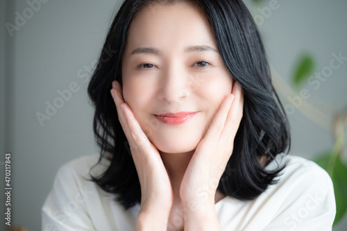 Beautiful Asian (Japanese) woman smiling, concerned about her skin condition Close up Front view, looking at camera