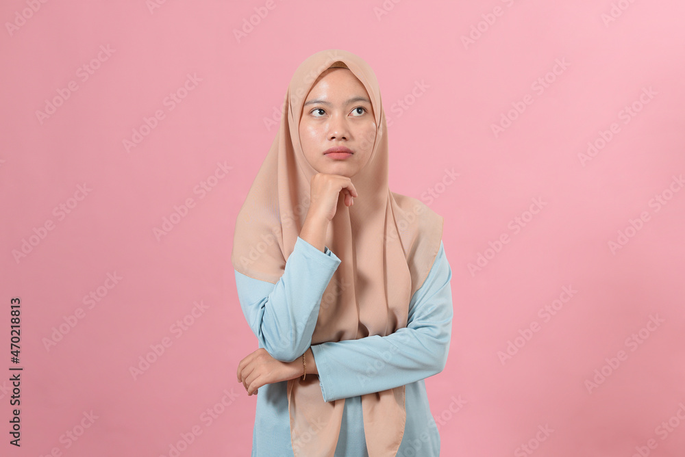 Young Asian muslim woman looking at a copy space or thinking an idea Young Asian muslim woman looking at a copy space or thinking an idea