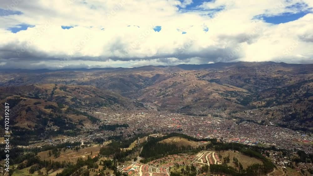 Aerial view from drone panning El Pinar and the city of Huaras in with white cotton clouds and blue sky and with mountains and pine forests Aerial view from drone panning El Pinar and the city of Huaras in with white cotton clouds and blue sky and with mountains and pine forests
