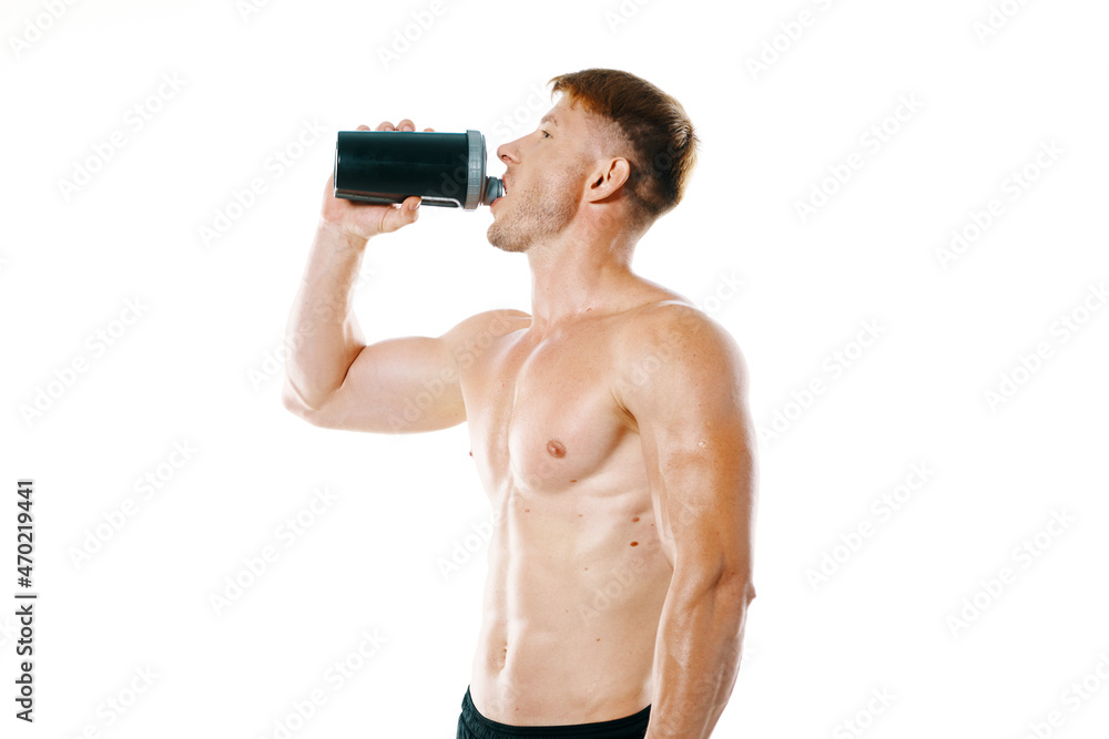 a man an athlete with a pumped-up body drinks from a bottle a man an athlete with a pumped-up body drinks from a bottle