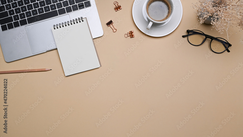 Comfortable workspace with laptop computer, notepad, glasses and coffee cup  on beige background. Stock-Foto | Adobe Stock