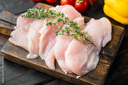 Photo Raw chicken cutlet breast fillets, on old dark  wooden table background