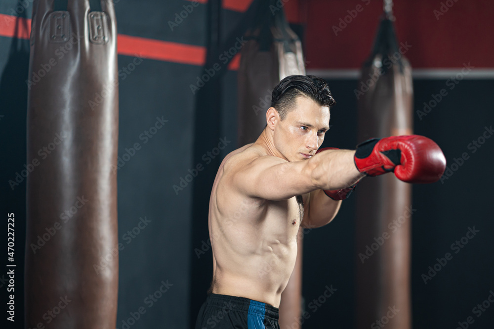 Adult Caucasian shirtless men wearing boxing glove and exercise inside of the fitness gym or sport club.