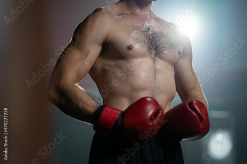 Unidentified Adult Caucasian shirtless men wearing boxing glove and exercise inside of the fitness gym or sport club.