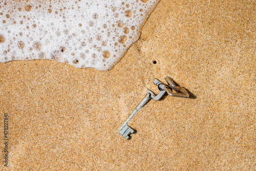 Billede på lærred Lost keys half buried in beach sand