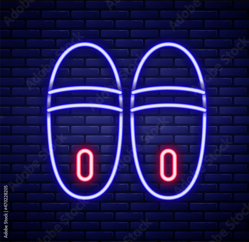 Glowing neon line Slippers icon isolated on brick wall background. Flip flops sign. Colorful outline concept. Vector