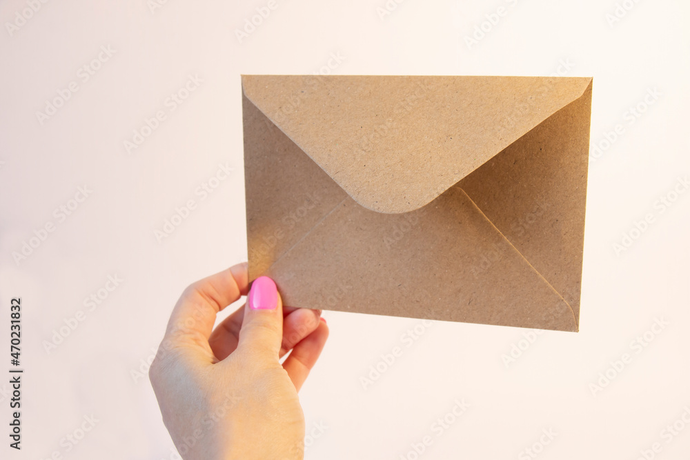 Female hand with paper envelope on white background