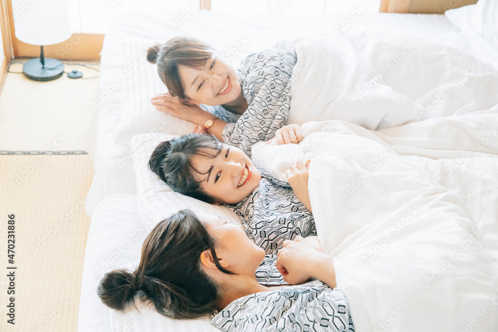 女子旅・布団でくつろぐ女性たち
女子旅・布団でくつろぐ女性たち