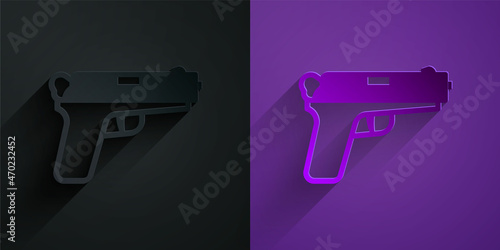Paper cut Pistol or gun icon isolated on black on purple background. Police or military handgun. Small firearm. Paper art style. Vector