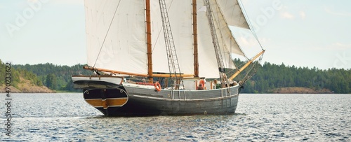 An elegant two-masted gaff schooner (training tall ship) sailing in Mälaren lake, Sweden. Travel, history, traditions, transportation, sailing, sport, cruise, regatta, teamwork. Panoramic view photo