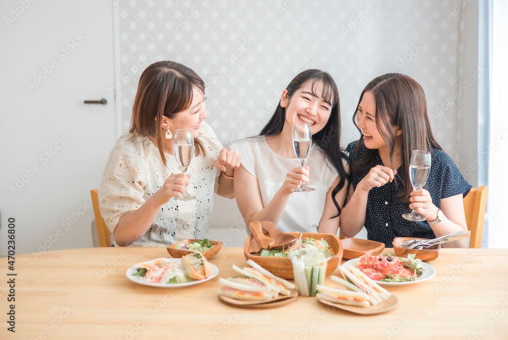 家でパーティーする女性たち（シャンパン・爆笑・酔う）
