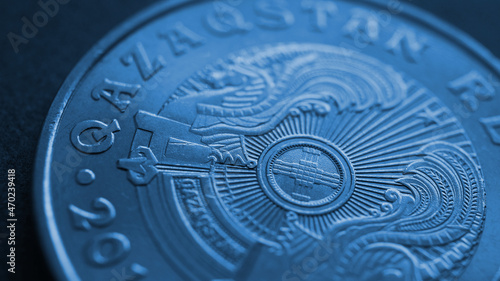 Translation: Kazakhstan. Kazakh 50 tenge coin with the country's emblem and focus on shanyrak. Blue tinted background or wallpaper about economy. Macro