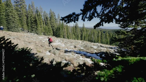 Man hiking through the mountains while camping. In beautiful Colorado looking for a spot to pitch his tent. photo