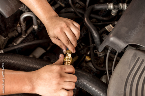 Connecting the oil fill duct to a oil flushing machine via an adapter. Maintenance procedure for a diesel SUV. photo