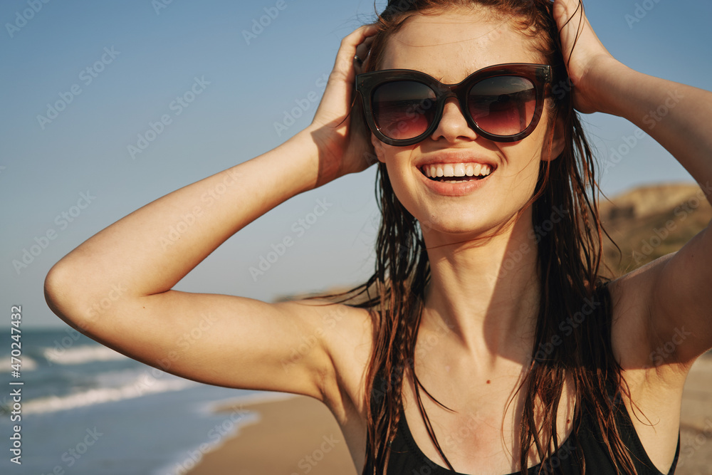 cheerful woman in sunglasses in a swimsuit on the beach sun island cheerful woman in sunglasses in a swimsuit on the beach sun island
