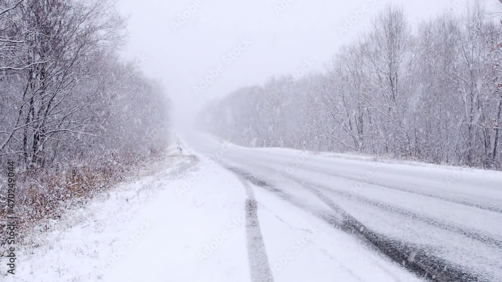 Empty car road during snowfall in winter, poor visibility for drivers. Empty car road during snowfall in winter, poor visibility for drivers.
