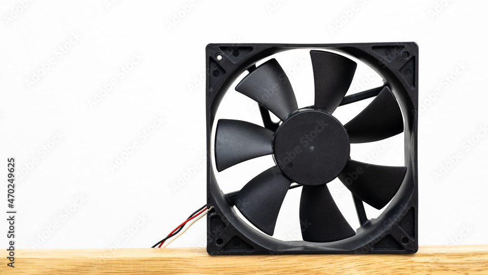 Close-up view of a computer fan isolate is placed on a wooden floor . Close-up view of a computer fan isolate is placed on a wooden floor .