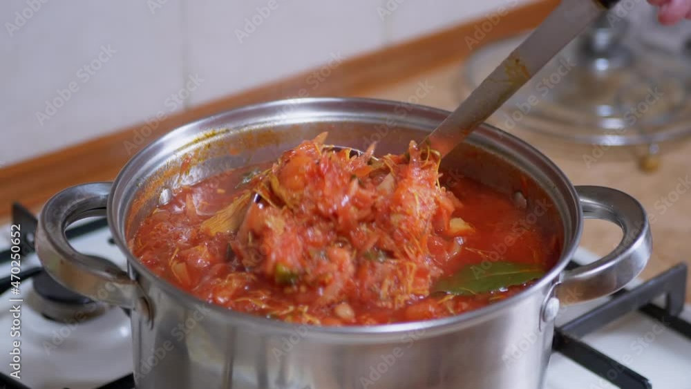 Preparing Rich, Thick, Red Borscht from Meat, Beet in a Saucepan in Home Kitchen. Vegetarian food made from vegetables, potatoes, carrots. Traditional, national food of Ukrainian and Russian cuisine.