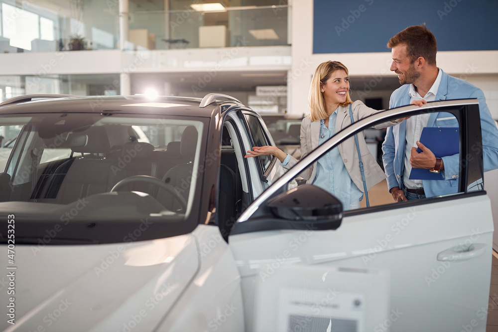 Smiling  female in the car dealership saloon buying  car
