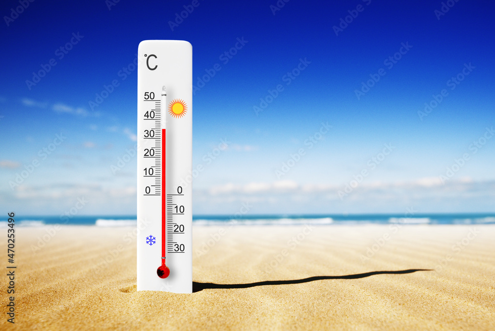 Hot summer day. Celsius scale thermometer in the sand. Ambient