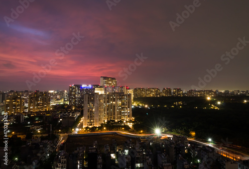 Beautiful view of city lights light trails colorful sky at night during monsoons in Delhi NCR   s posh locality with urban cityscape residential apartments and commercial business hub on July 20 2021.